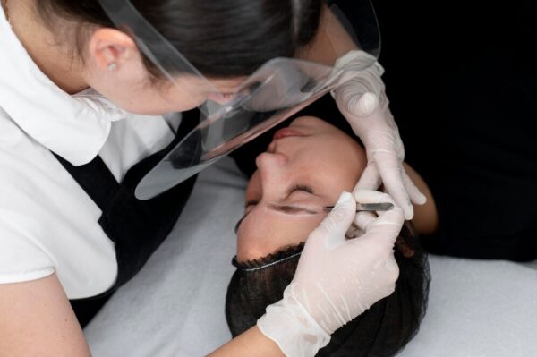 Microblading technician applying pigment during a microblading class